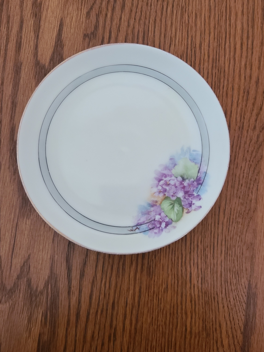 Antique, hand-painted porcelain cabinet plate decorated with purple violets